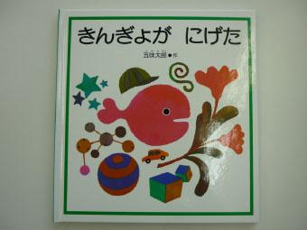 ピンク色の金魚と周りに星、ボール、花、車などのイラストが描かれてある、きんぎょが にげたの表紙写真