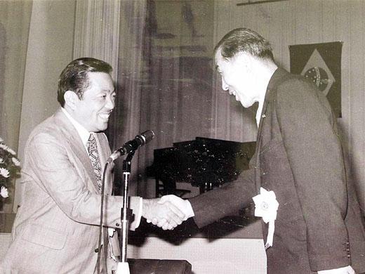 2名の男性が笑顔で握手をしている白黒写真